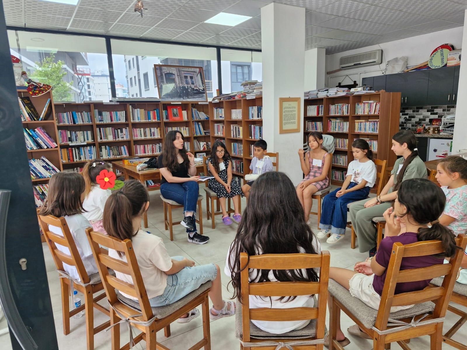 Kütüphanede Hilal Kurt ile çocuklar çember halinde oturuyor